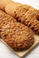 Assorted cookies with sunflower seeds and crunchy toppings displayed on a wooden platter