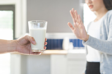 Allergy asian young woman, girl hand in deny, no or push out to avoid for drink milk at home,...