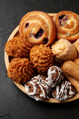Delicious assortment of baked goods arranged on a wooden platter showcasing various textures and...