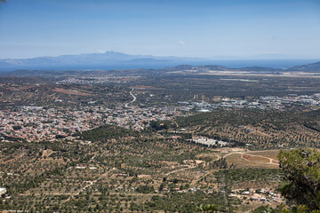 Panoramic view of Athens, Greece, showcasing the city's sprawling landscape, the surrounding hills, and the clear blue sky