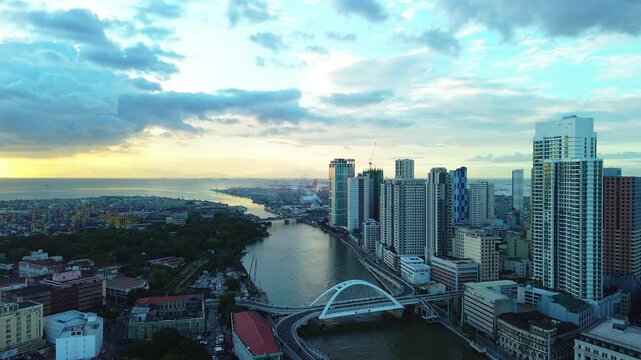 A serene aerial scene capturing Manila&rsquo;s Intramuros skyline and the Pasig River framed by a glowing sunset, blending historic charm with contemporary city life.