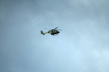 Helicopter is flying on isolated overcast mid-air sky