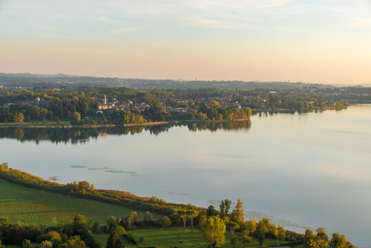 Aerial view of a lake in northern Italy at sunset. Lake Pusiano and the town of Bosisio Parini. Natural lake between the cities of Como and Lecco. It is one of the Brianza lakes in Lombardy Region