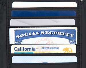 Social Security card in a black wallet with credit cards and CA drivers license. SS number is a nine digit number issued to U.S. Citizens and is required to legally be employed in the United States