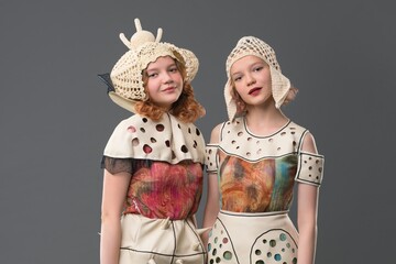 Young models showcase creative fashion in unique designs at studio setting