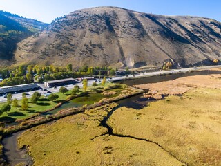 High-angle view of a town nestled in a valley, alongside a highway and a marsh. Cars travel on the highway, showcasing the landscape's beauty. , Jackson, Wyoming, USA.