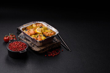 Baked salmon pieces with potatoes, cheese and olives