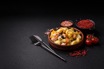 Baked salmon pieces with potatoes, cheese and olives