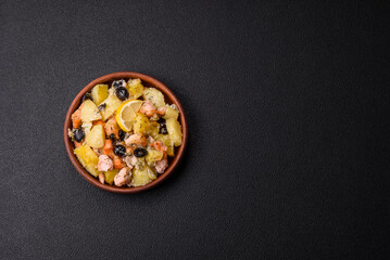 Baked salmon pieces with potatoes, cheese and olives