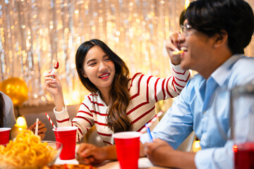 Three friends joyfully celebrating drinking eating drinking and cheerful expressions at house party