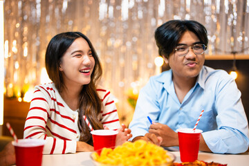 Three friends joyfully celebrating drinking eating drinking and cheerful expressions at house party