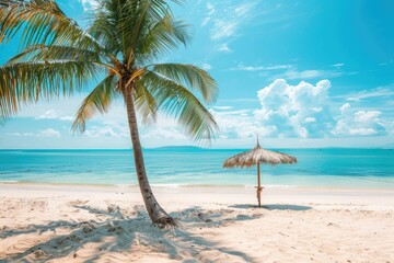 Obraz premium A serene tropical beach features a tall palm tree and a straw umbrella on soft sand, with calm turquoise waters and fluffy clouds in the distance on a sunny day
