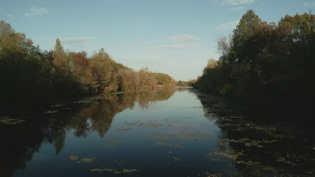 Calm Volga river reflecting autumn colors at sunset