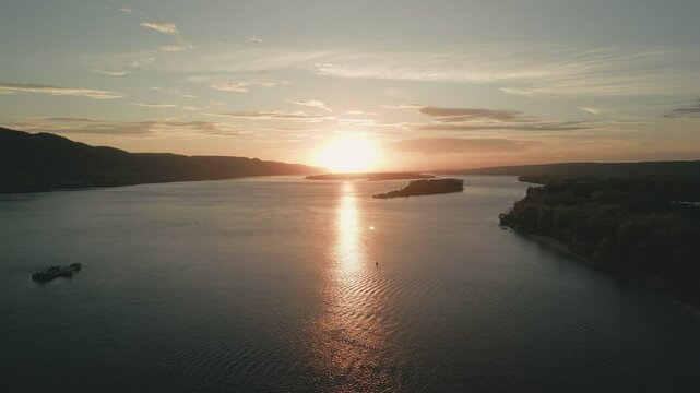 Cargo ship sailing on river at sunset