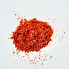 Pile of red paprika or hot chili pepper flakes powder isolated on square white background.