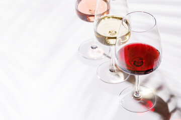 Three wine glasses filled with red, white, and rose wine