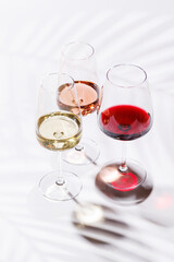 Three wine glasses filled with red, white, and rose wine
