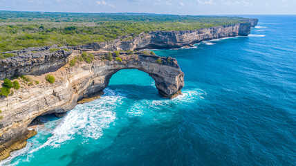 Natural stone arch surrounded by turquoise water
