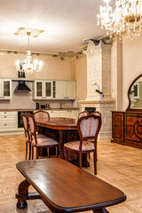 Interior view of a dining area with a wooden table, vintage sideboard, floral tiled stove, modern kitchen appliances, and parquet flooring.