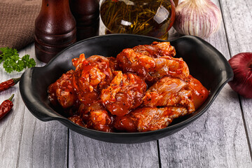 Raw marinated buffalo chicken wings