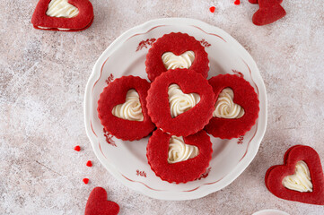 Red velvet sandwich cookies in the shape of a heart with cream cheese filling for Valentines day. Holiday dessert. Copy space.