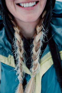 smiling woman in winter with frost covered blond braids in hair