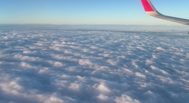 Vista desde la ventana del avi&oacute;n, cielo descubierto, oleaje del mar de nubes, atardecer, volando a gran altitud, espacio a&eacute;reo, vista panor&aacute;mica, tierra, horizonte, seguro de viajes