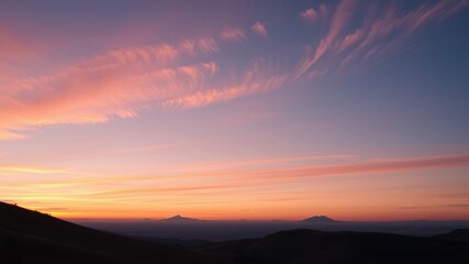 Obraz premium Serene Sunset Over Distant Mountain Ranges with Painted Sky