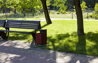 Rest area with benches surrounded by trees and ornamental shrubs in Kyiv, Europe. Place to rest in the city park at summer
