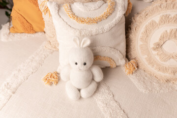 White knitted bunny. Boho style.Location for a photo shoot.