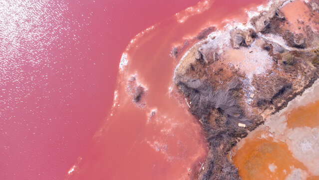 Pink lake torrevieja salt mine reflecting sunlight at sunset, aerial view