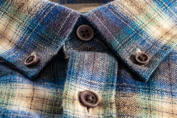 Close-up of a blue and beige plaid flannel shirt with button details.