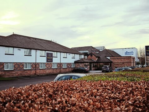 Suburban Hello hotel and restaurant Swinton with parked cars on an overcast day.