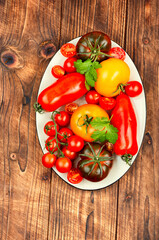 Ripe tomatoes on rustic wooden background.