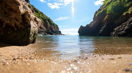 Fototapeta premium Tranquil Beach View Between Rugged Cliffs Under Bright Blue Sky and Soft White Clouds