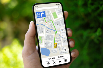 man hand hold phone with navigation application screen on street
