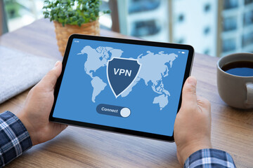 male hands hold computer tablet with app vpn on screen