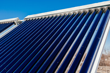 Close-up of a solar water heater, with a solar panel designed for efficient water heating. Clear blue sky in the background, showcasing renewable energy and eco-friendly technology. © wedmoments.stock