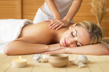 Obraz na płótnie Canvas Woman receiving a back massage in a serene spa. Warm, peaceful setting with wooden background. Concept of relaxation, wellness, and self-care. Ai generative
