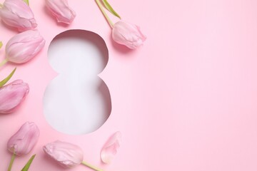 Paper cut out figure eight on pink background with fresh tulips. Concept of 8 march, Women's day