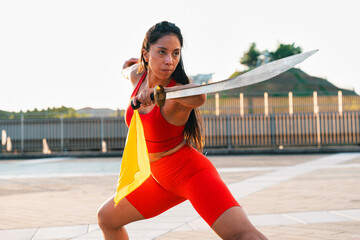 Chinese young woman practicing wushu kung fu with weapons outdoor. Young girl training martial arts...