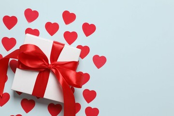 Gift box with red hearts on color  background