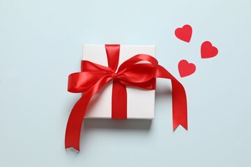 Gift box with red hearts on color  background