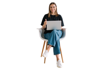 cheerful young woman sitting on a chair, working on a laptop, giving a thumbs-up gesture.