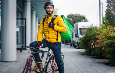 Food delivery rider on his bicycle. Image of a middle age man at work in the city center....