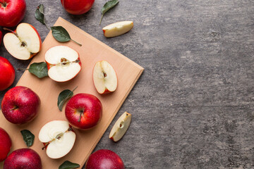 Fresh red apples with green leaves on table. cutting board with knife. Top view