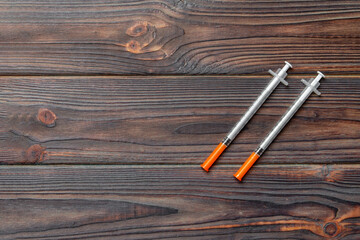 Top view of insulin syringe prepared for injection at wooden background. Diabetes concept with copy...