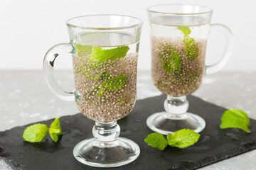 Healthy breakfast or morning with chia seeds and mint on table background, vegetarian food, diet and health concept. Chia pudding with and mint