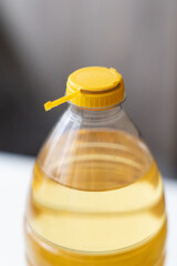 Yellow plastic cap for PET bottle with sunflower oil. New design with less plastic, the cap remains attached to the bottle after opening. Designed to reduce plastic waste.