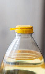 Yellow plastic cap for PET bottle with sunflower oil. New design with less plastic, the cap remains attached to the bottle after opening. Designed to reduce plastic waste.